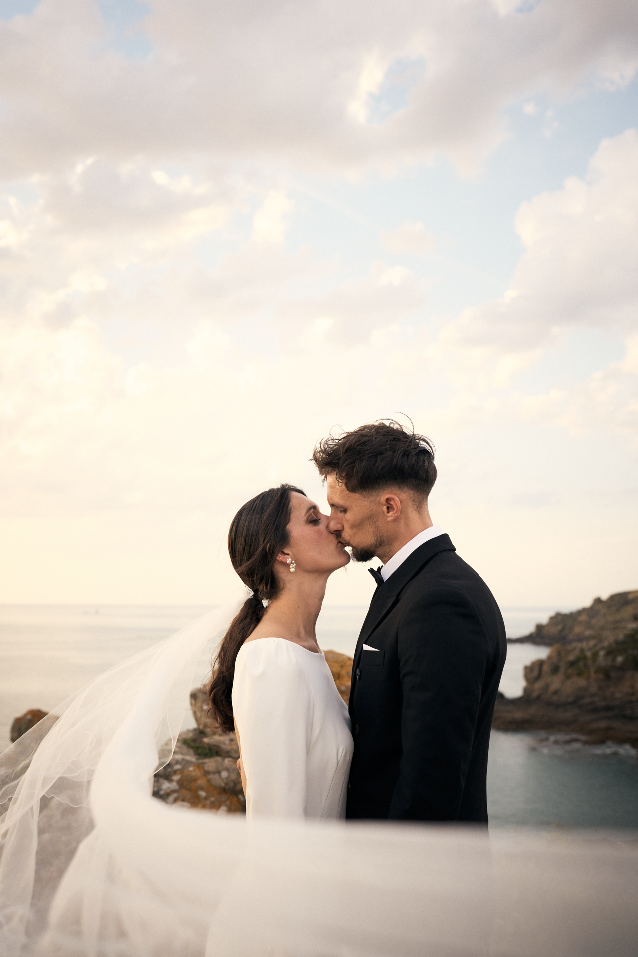 Couple de mariés s’embrassant en extérieur pendant leur reportage mariage