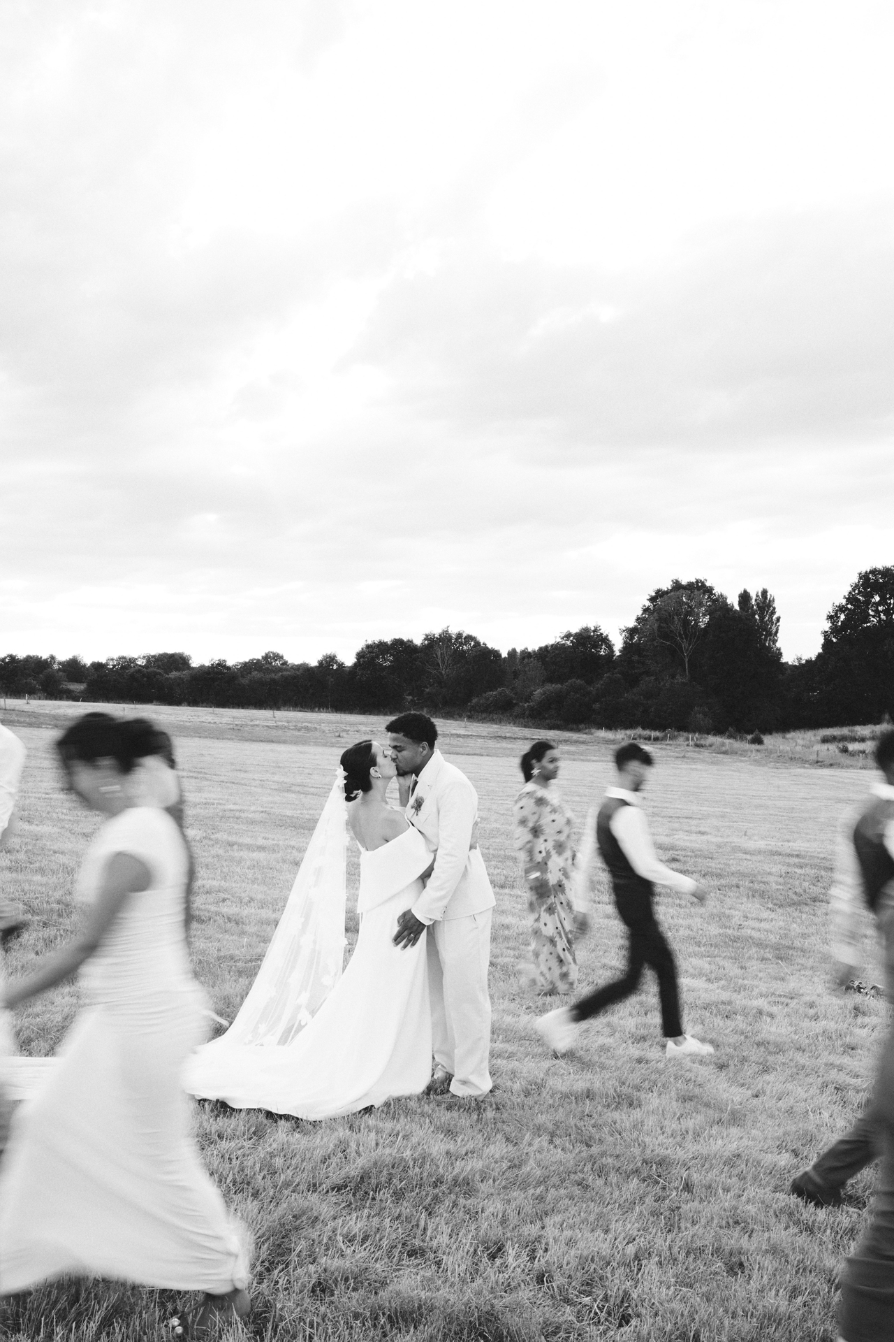 Mariés s’embrassant au milieu de leurs invités pendant leur mariage au Logis Mayennais
