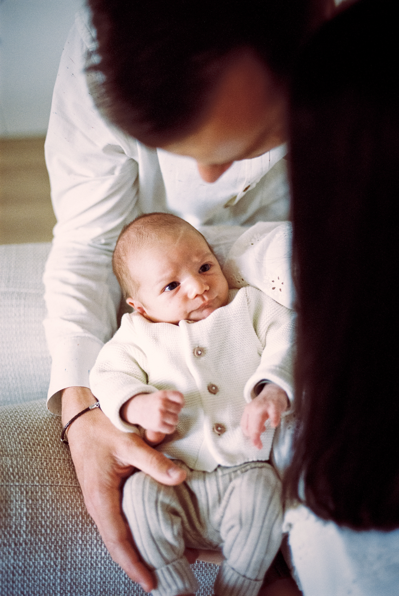 Parents avec leur nouveau-né lors d’une séance photo naissance à domicile