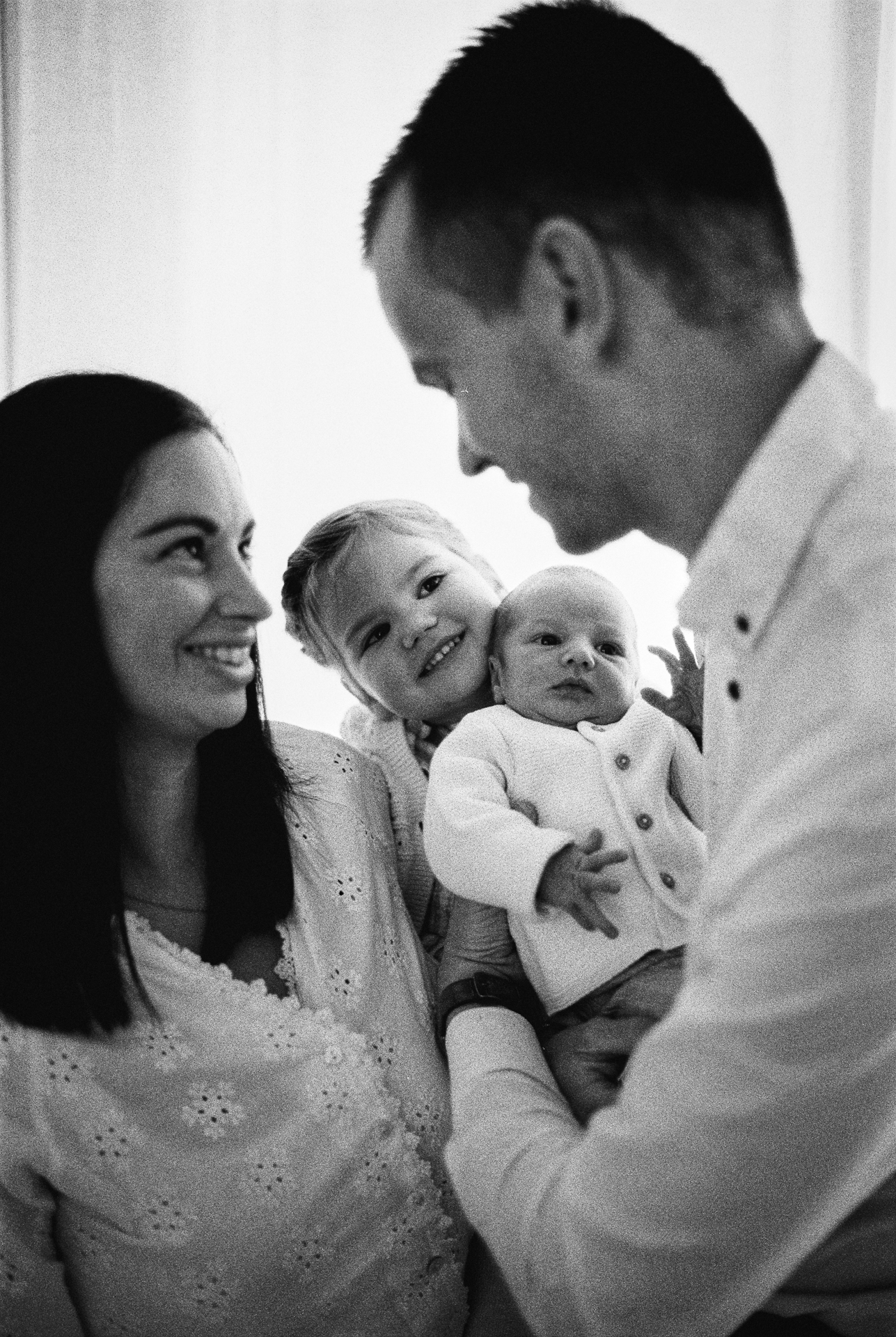 Parents et leur fille réunis autour de leur nouveau-né lors d’une séance photo en famille