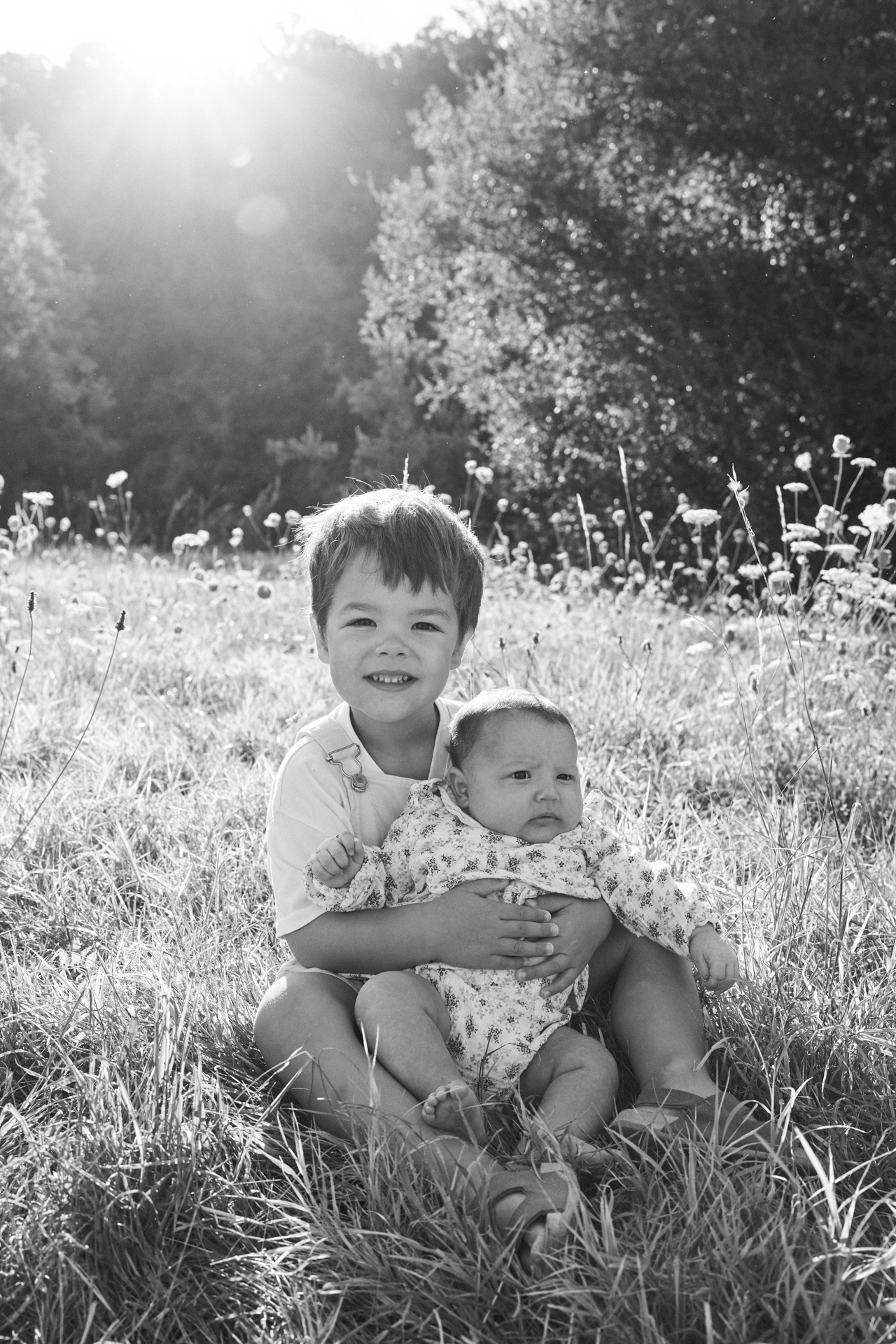 Parents avec leurs deux enfants photographiés en noir et blanc au bord de l’eau